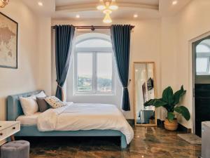 a bedroom with a bed and a large window at Sally Villa Homestay in Da Lat
