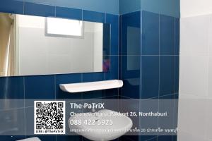 La salle de bains est pourvue de carrelage bleu, d'un lavabo et d'un miroir. dans l'établissement The PaTriX Chaengwattana, à Nonthaburi