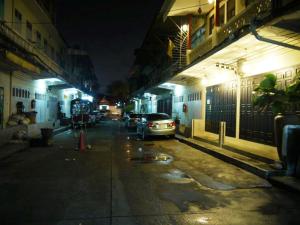 un coche aparcado en una calle de la ciudad por la noche en The Royal ThaTien Village, en Bangkok