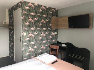 a bedroom with a wall with a pattern of pink flamingos at Hôtel Heod - Binic - Saint-Quay-Portrieux in Étables-sur-Mer