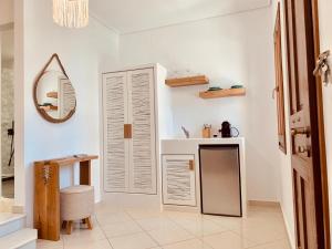 a bathroom with white walls and a mirror and a sink at Villa Christine in Agia Anna Naxos