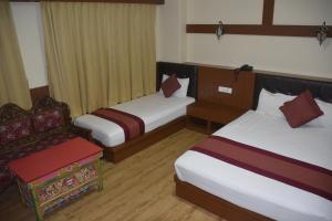 Ein Bett oder Betten in einem Zimmer der Unterkunft Juniper Residency Hotel