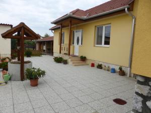 una casa con patio y una casa con porche en Napfény Apartman és Vendégház, en Egerszalók