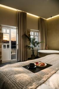 a bedroom with a bed with a plate of food on it at Divino Suites Chania in Chania Town