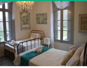 a bedroom with two beds and two windows at Le Petit Chateau in Puilaurens
