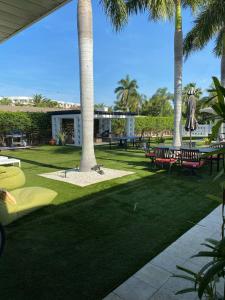 un parc avec des palmiers, des bancs et des tables dans l'établissement Captiva Beach Resort (open private beach access), à Sarasota
