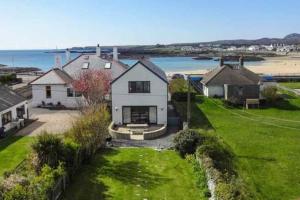 an aerial view of a house with a view of the ocean at TULLOCHSIDE-4 BED-SEA FRONT -RAVENSPOINT ROAD in Trearddur