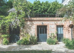 an old brick building with a door and trees at Les Tilleuls Etretat in Étretat