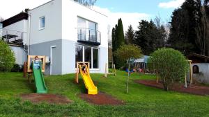 a yard with playground equipment in front of a house at Pension Irlingerhof in Mondsee