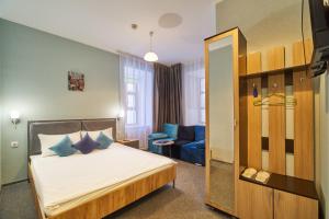 モスクワにあるHalva Hotel Polyankaのベッドルーム(ベッド1台、青いソファ付)