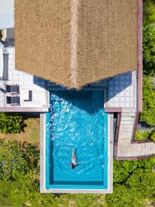 een uitzicht op een persoon die in een zwembad zwemt bij Purana Resort Koh Yao Noi - SHA Extra plus in Ko Yao Noi