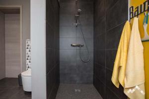 a bathroom with a shower with yellow towels at Gîte citadin 3 épis "CARPE DIEM" in Bastogne