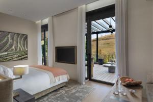 sypialnia z łóżkiem i przesuwnymi szklanymi drzwiami w obiekcie Six Senses Douro Valley w mieście Lamego