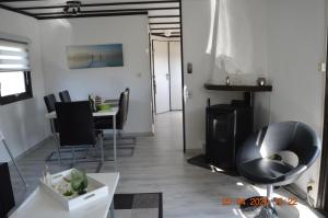ein Wohnzimmer mit schwarzen Stühlen und einem Tisch in der Unterkunft Vakantie Chalet Makkum in Makkum