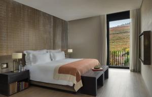 sypialnia z dużym łóżkiem i dużym oknem w obiekcie Six Senses Douro Valley w mieście Lamego