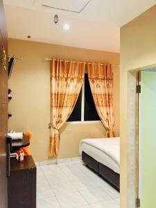 1 dormitorio con cama y ventana en Hotel Anda en Pematangsiantar