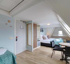 Schlafzimmer mit einem Bett, einem Tisch und Stühlen in der Unterkunft Hotel Duinlust in Domburg