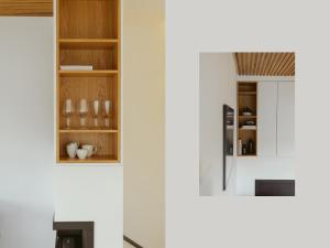 cocina con paredes blancas y armarios de madera en Bosky Apartament, en Gródek Nad Dunajcem