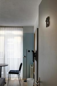 een woonkamer met een stoel en een tafel bij Hotel Duinlust in Domburg