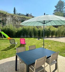 a blue table with chairs and an umbrella at Gîte Bambou in Seigy