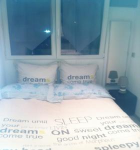 a bed with two pillows with the words dreamini keep your dream on my at Appartement Les Palmiers in Juan-les-Pins