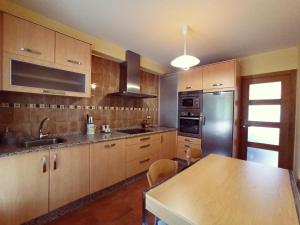 a kitchen with wooden cabinets and a stainless steel refrigerator at Casa Mar de Ardora in A Coruña