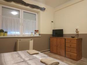 a bedroom with a bed and a dresser and a window at Cseresznyés Ház in Lipót