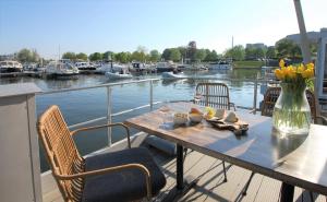 een tafel met stoelen en een vaas met bloemen op een boot bij Tiny floating house, Mallorca in Maastricht