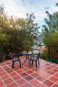 eine Terrasse mit 2 Stühlen und einem Tisch auf der Terrasse in der Unterkunft Casa de Piedra Taganga in Taganga