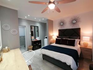 a bedroom with a bed and a ceiling fan at Roxy's Rest Guest House in Vanderbijlpark