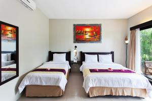 a bedroom with two beds and a window at Kebun Villas & Resort in Senggigi