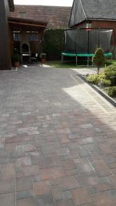 a brick patio with a green bench in a yard at Domček Janina in Suchá Hora