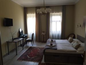 - un salon avec un lit, un bureau et un canapé dans l'établissement Kétbodonyi Apartments, à Kétbodony