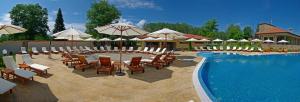 - une piscine avec des chaises longues et des parasols à côté d'un complexe dans l'établissement Къща Наковски, à Gabrovo