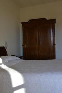 a bedroom with a bed and a wooden cabinet at La Locanda di Valbella in Asti