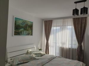 a white bedroom with a bed and a window at Casa Tomșa in Rozavlea