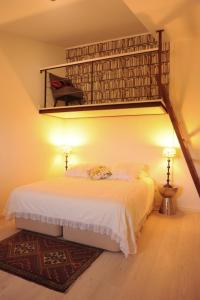 a bedroom with a bed and a loft bed with a ladder at Casa da Cisterna in Castelo Rodrigo