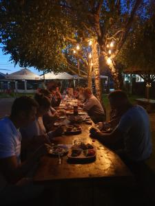 a group of people sitting at a long table at night at Casa Tomșa in Rozavlea
