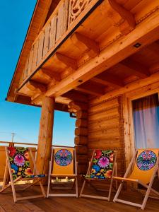 two chairs sitting on the porch of a cabin at Beskid Wood Houses in Jasnowice