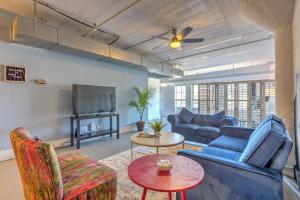 a living room with a blue couch and a tv at Vogue loft walk to CityMu/Cards/Aquarium/ConvCtr in Saint Louis