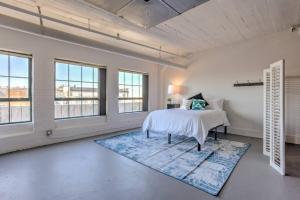 1 dormitorio con 1 cama y ventanas grandes en Vogue loft walk to CityMu/Cards/Aquarium/ConvCtr, en Saint Louis