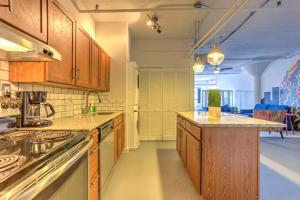 a large kitchen with wooden cabinets and a counter top at Vogue loft walk to CityMu/Cards/Aquarium/ConvCtr in Saint Louis