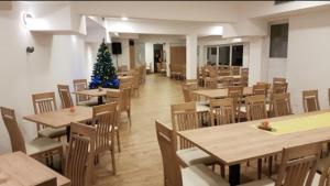 a dining room with tables and a christmas tree in it at Hotel and Restaurant Ana in Hrib-Loški Potok