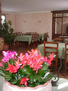 un jarrón de flores rosas sobre una mesa en un restaurante en Agriturismo Cascina Gilli, en Spino dʼAdda