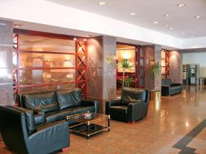 a lobby with two leather chairs and a table at Mercure Andorra in Andorra la Vella