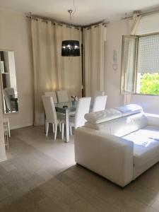 a living room with a white couch and a table at Hotel Flora in Milano Marittima