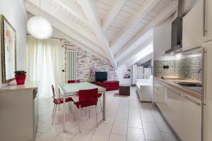 a kitchen and dining room with a table and red chairs at Hotel Flora in Milano Marittima