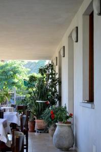 a restaurant with tables and potted plants on a patio at La Locanda di Valbella in Asti +24 photos