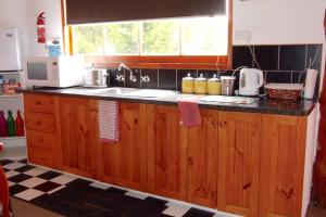 a kitchen with wooden cabinets and a sink and a window at BEAUTIFUL RETREAT - 20 mins to CBD and only 10 mins to MONA! in Collinsvale