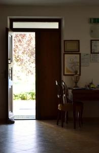 - une porte ouverte menant à une salle à manger avec une table et des chaises dans l'établissement La Locanda di Valbella, à Asti